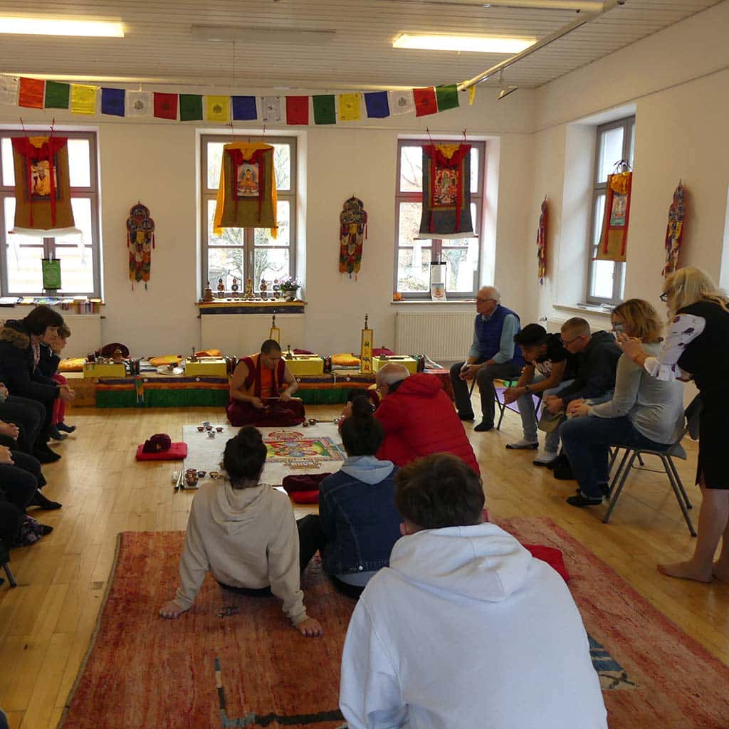Gäste bestaunen die kunstvolle Arbeit tibetischer Mönche in Friedberg (Bayern)
