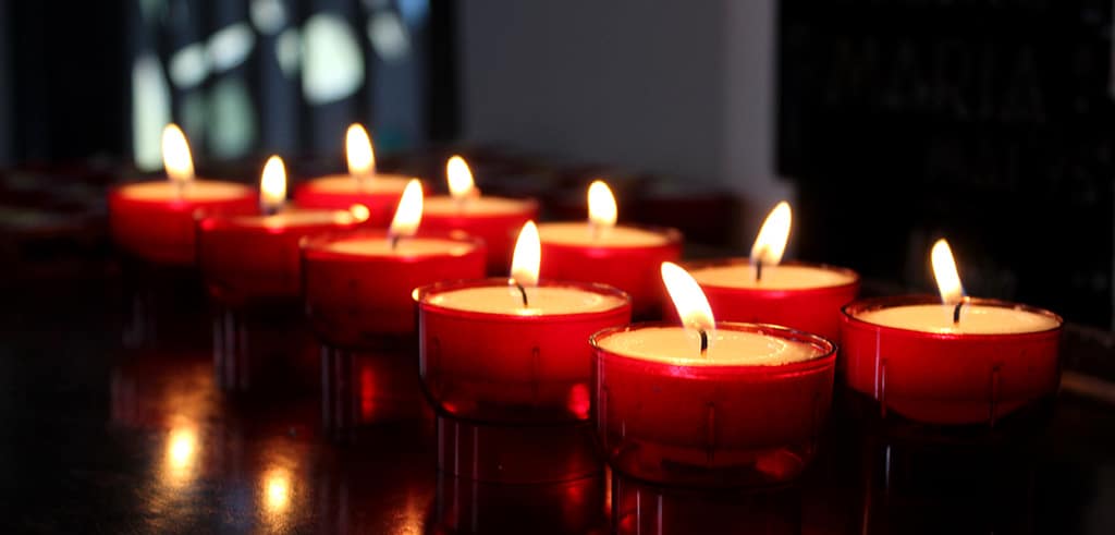 In einer leeren Kirche eine Kerze entzünden