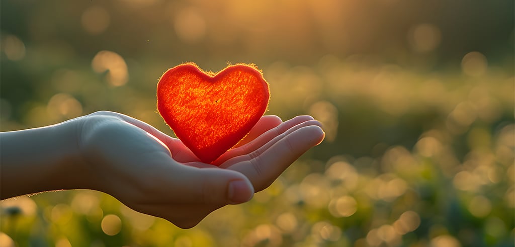Offene Hand mit rotem Herz – Symbolbild: Herz und Liebe